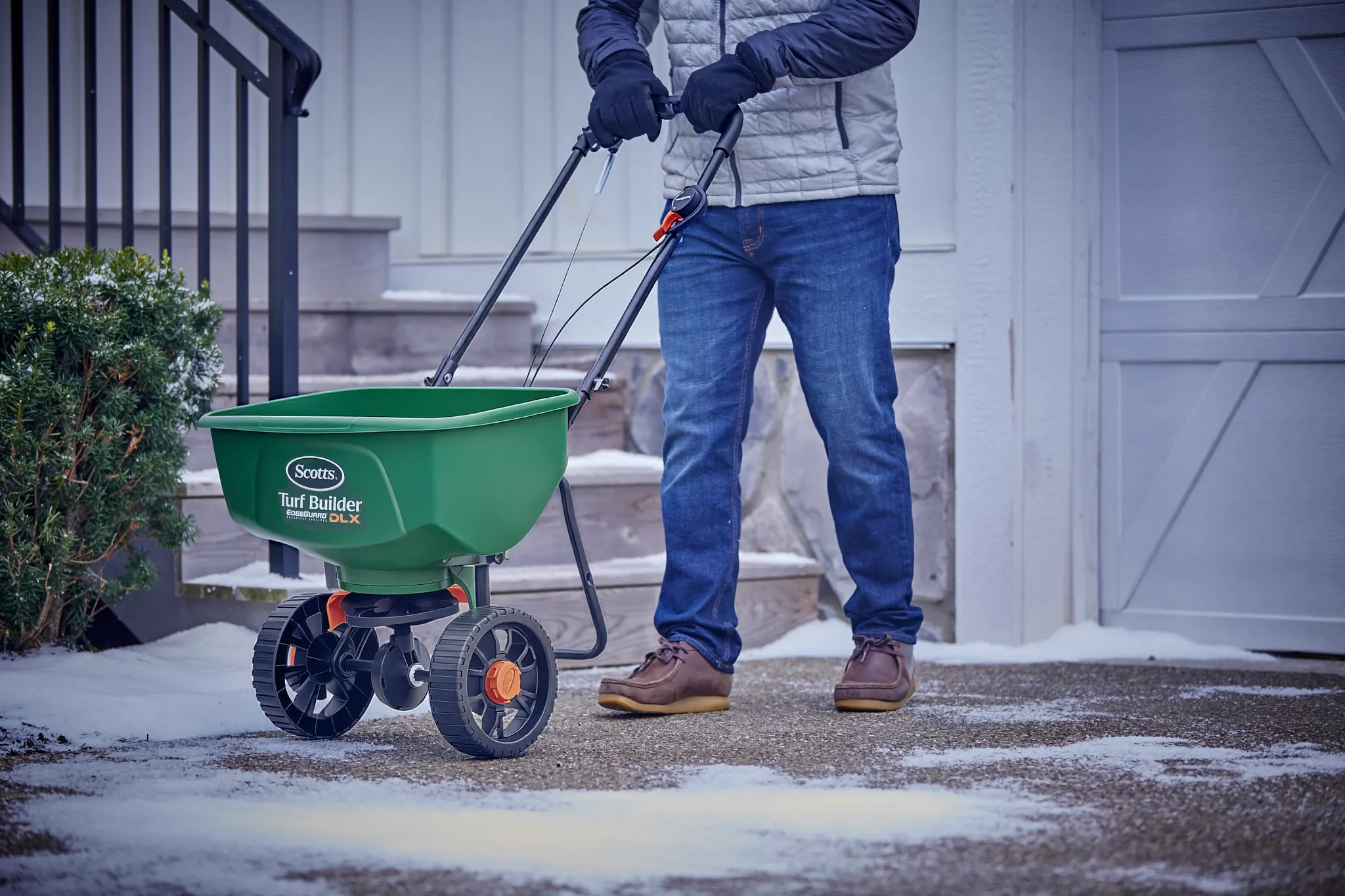 Using a Scotts DLX broadcast spreader to apply ice melt to a driveway