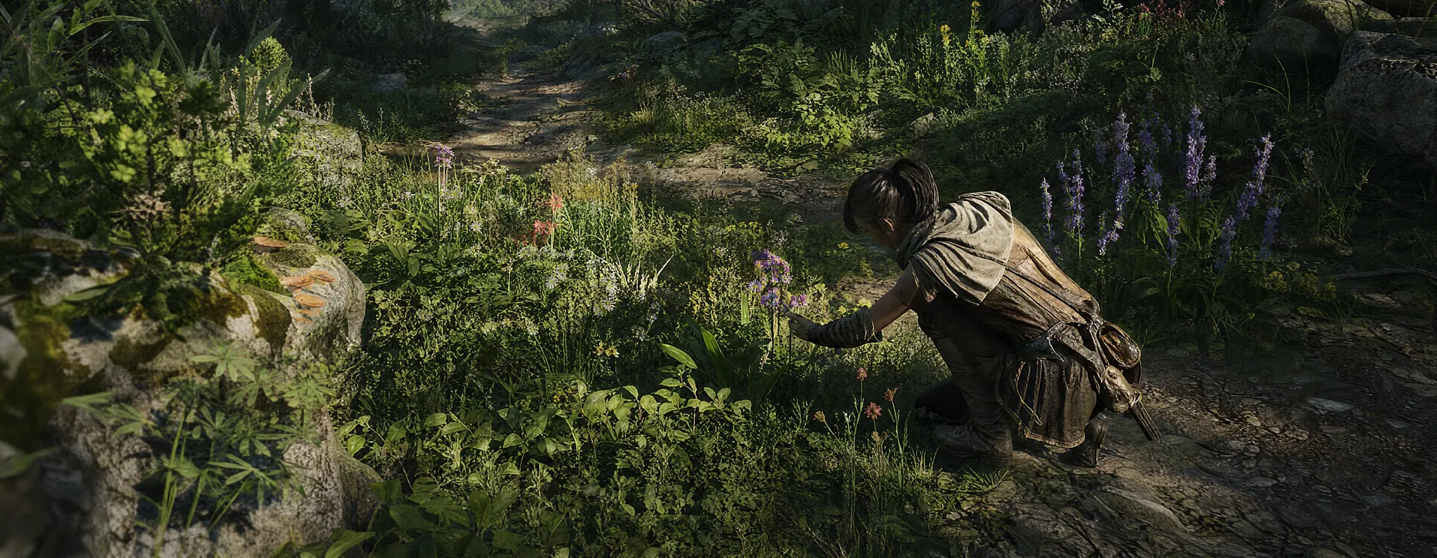 A video game character crouching near green plants and foliage in an outdoor grassy field.