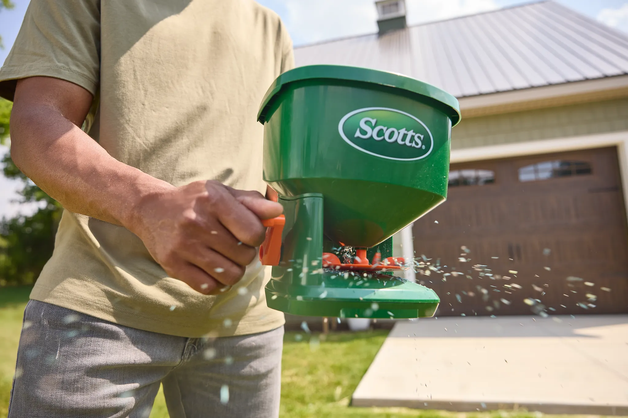 Scotts Whirl Hand-held Spreader applying grass seed