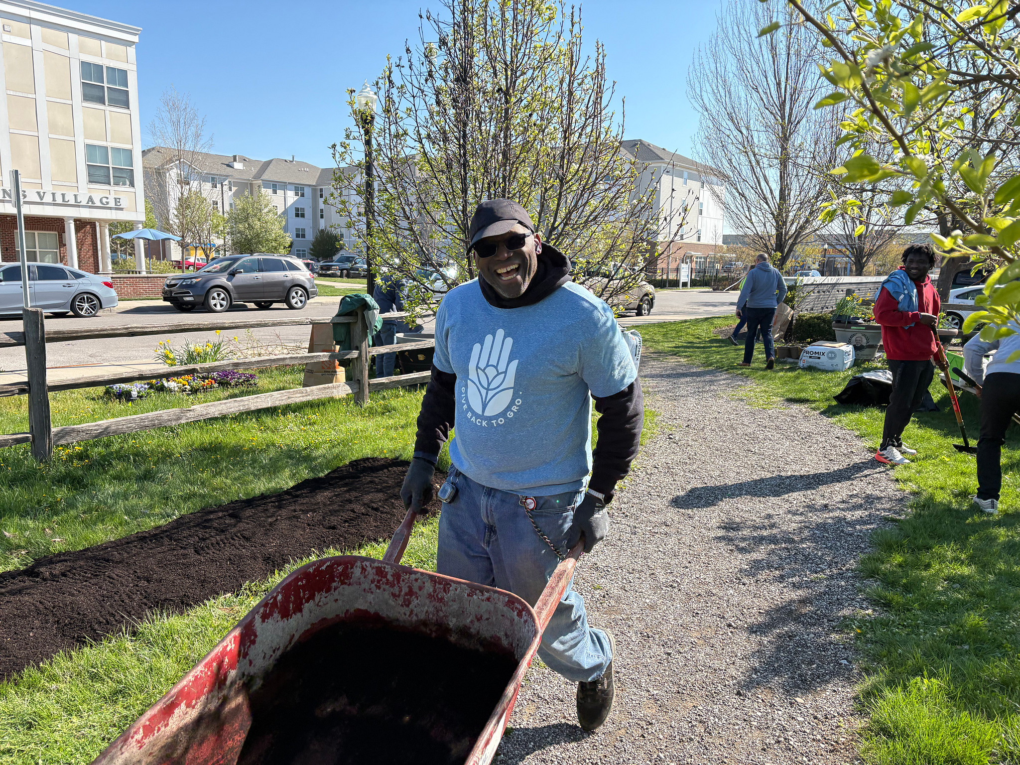 ScottsMiracle-Gro associate volunteering transporting dirt in wheelbarrel