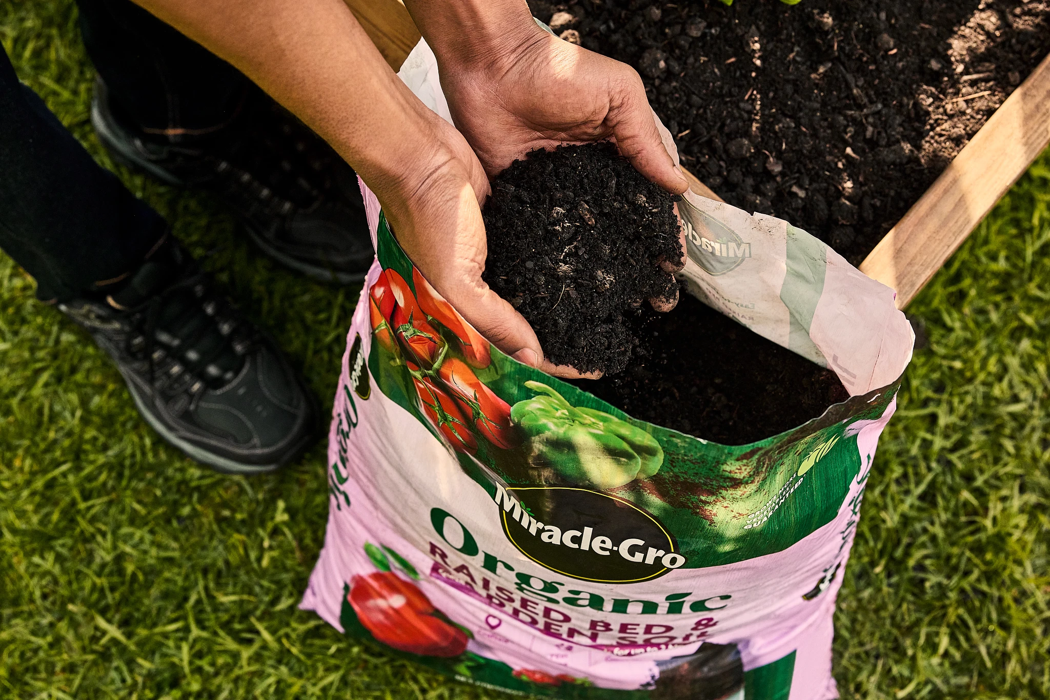 Hands holding peat-free Miracle-Gro Organic Raised Bed & Garden Soil