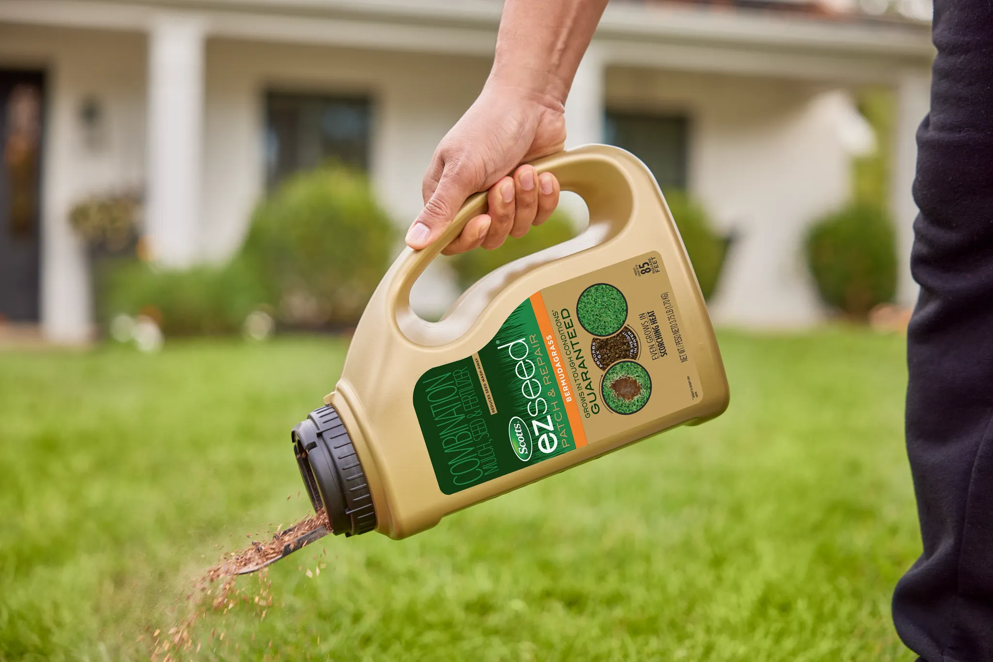 Applying EZ Seed Bermudagrass to a bare spot in the lawn using the shaker jug.