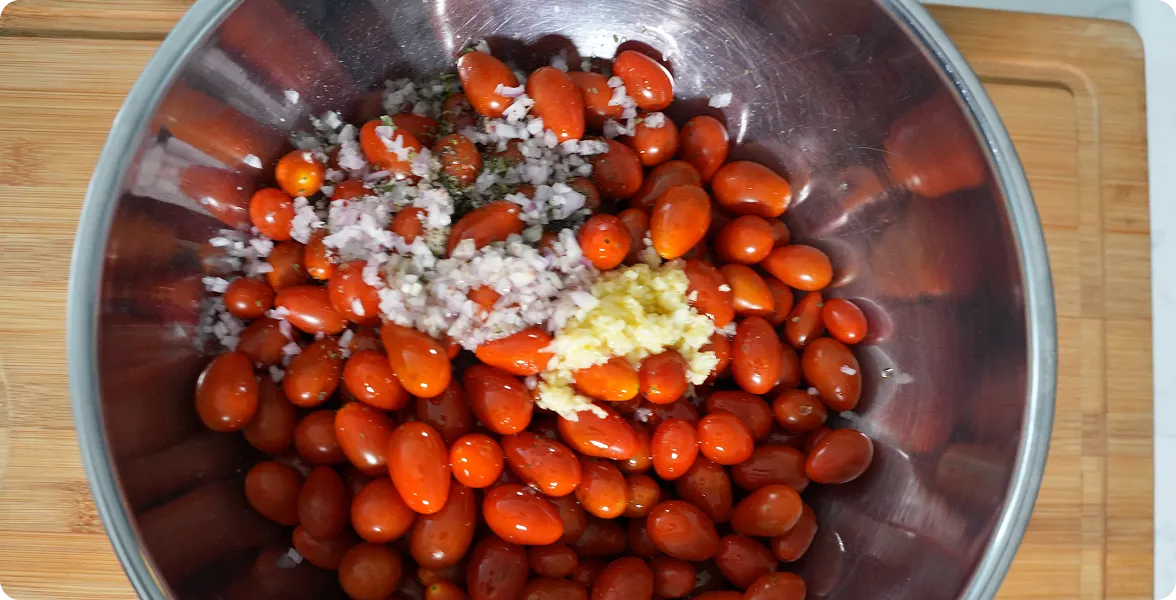 Photo of cherry tomatoes, garlic, and ingredients mixed in a baking dish, set next to an editorial article section titled "Even lazy cooks love it" discussing how simple and popular the roasted sauce recipe is. 