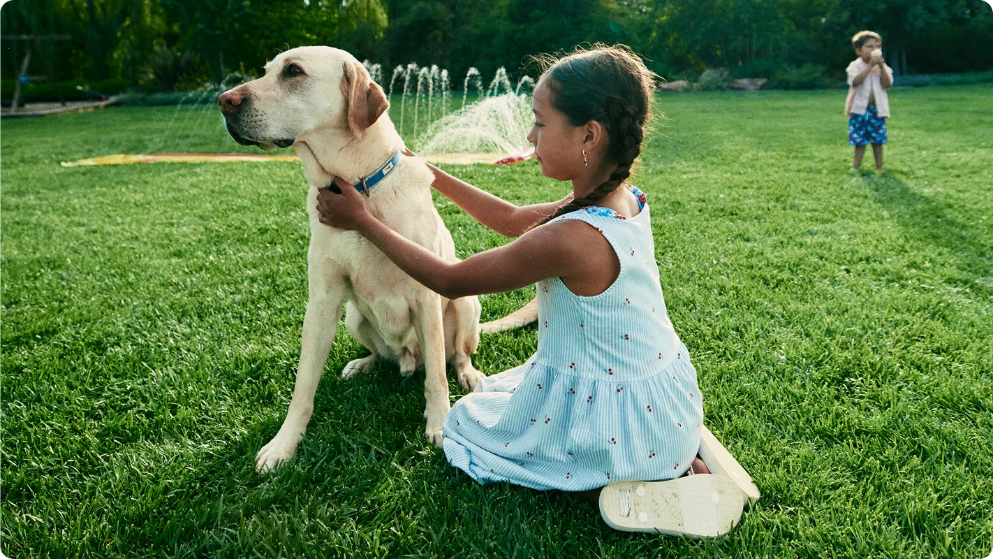 A little girl hugging her dog