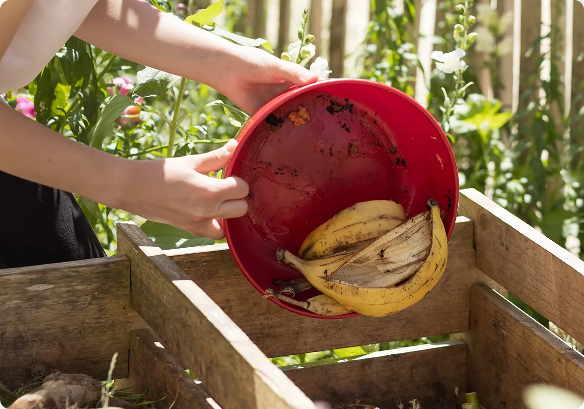  Photo of a student placing food scraps into a compost bucket, accompanying article section titled "4. The Standout Compost Curriculum" in Los Angeles, CA, which highlights student food waste reduction efforts. 