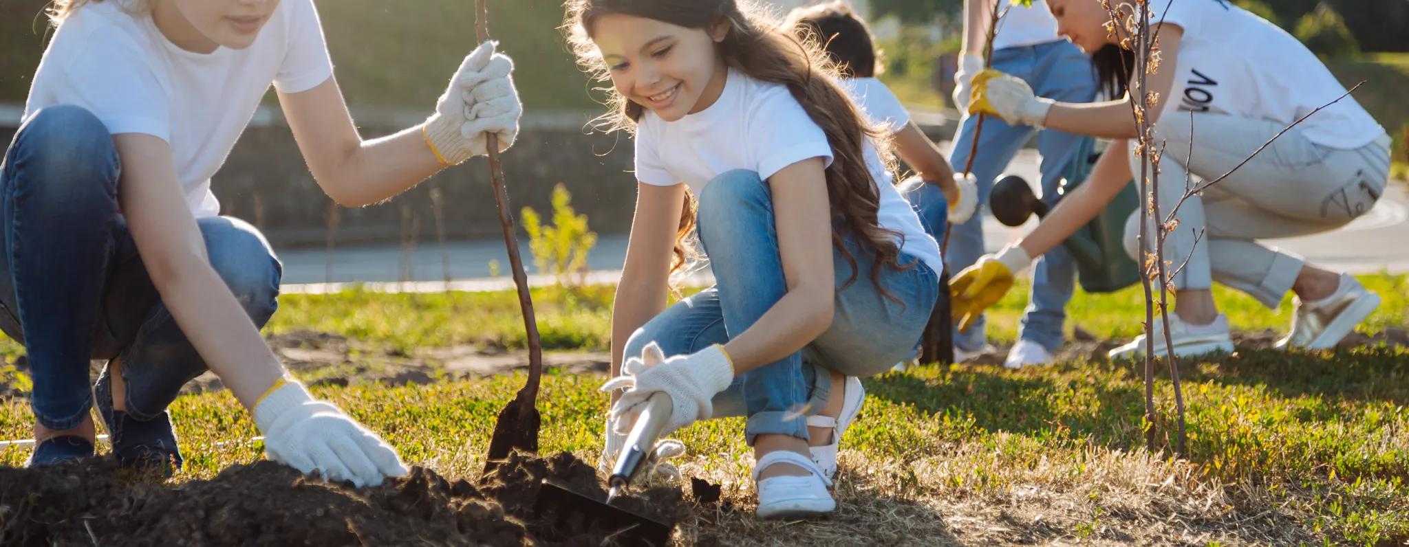 Editorial header titled "How We're Growing the Next Generation of Gardeners" above a photo of a young girl holding fresh green vegetables. Accompanying text details grassroots grants, Head Start gardens, and school programs.