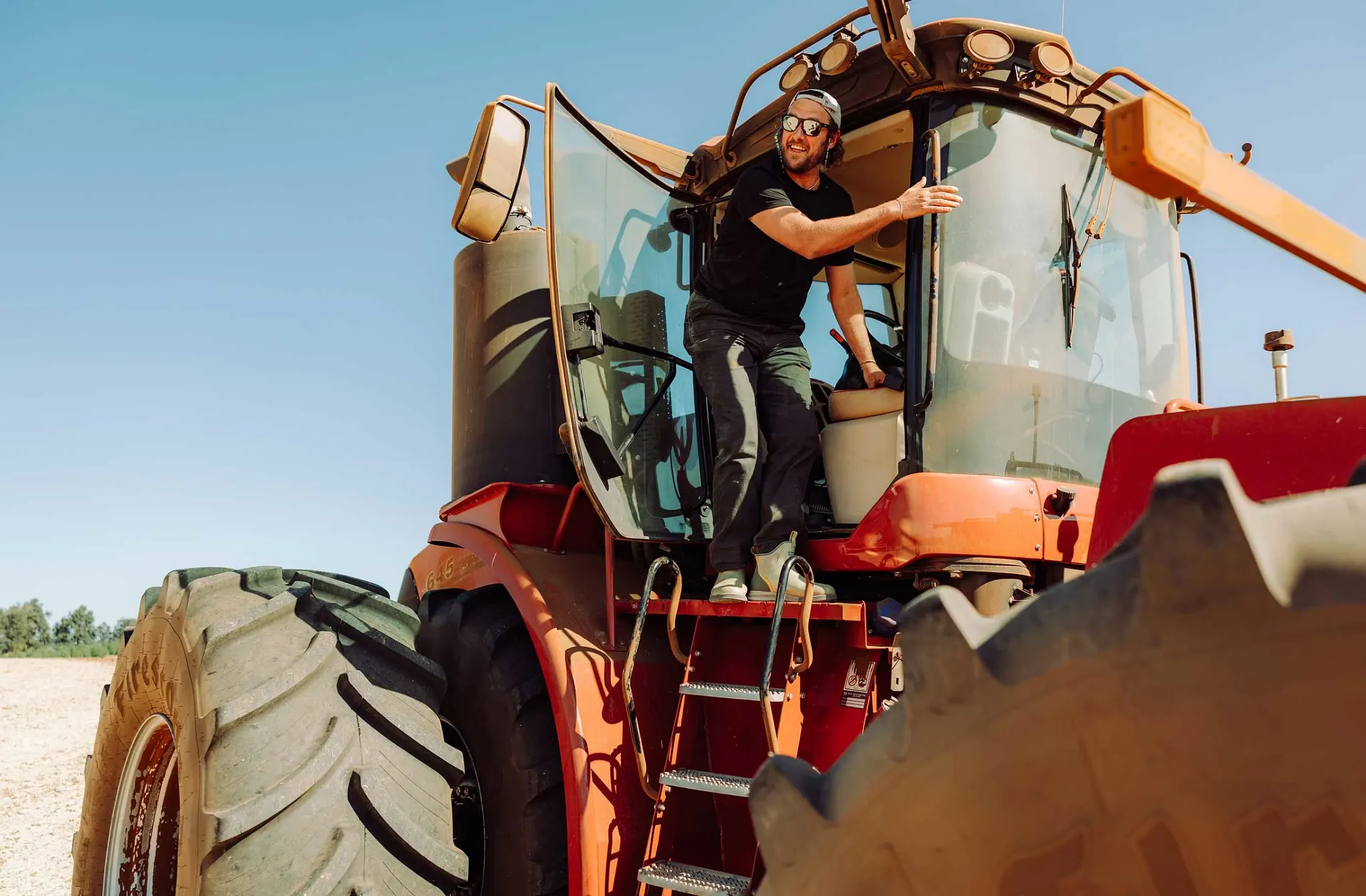 Person on a red, big wheel tractor stepping out of the door