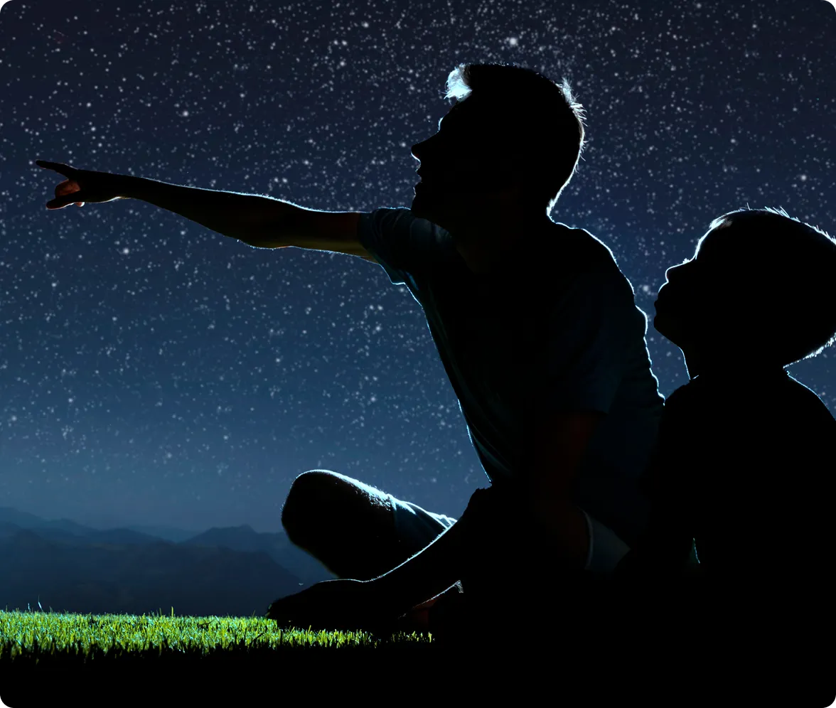Text reflecting on watching the Milky Way and feeling gratitude for family, nature, and starry night skies, shown alongside a photo of a father and son sitting in the grass at night pointing up at a star-filled sky.