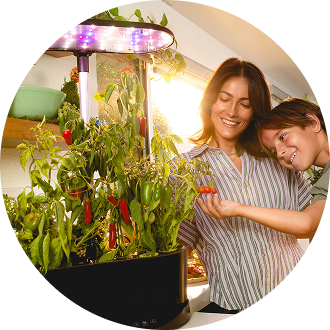 woman and child with aerogarden filled with peppers